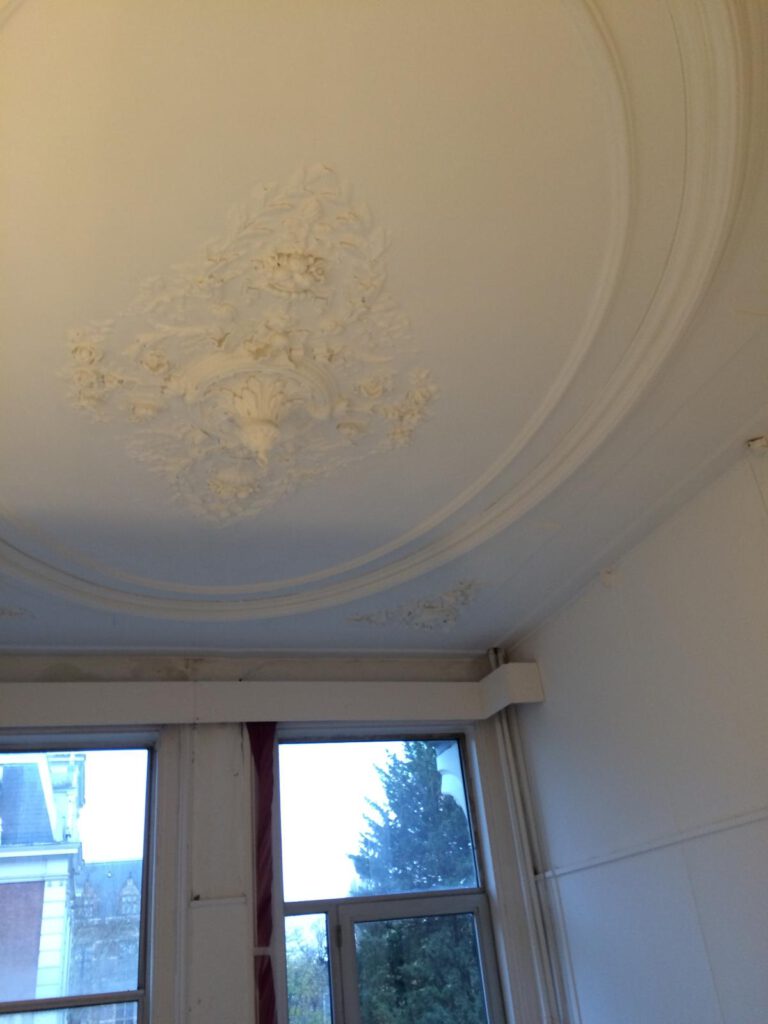 Elegante plafondornamenten met klassieke details na restauratie door Elviservices.
