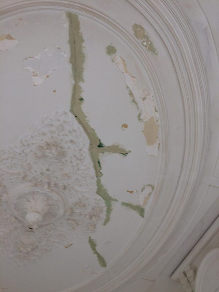 Detail van een plafond met zichtbare schade tijdens restauratie door Elviservices.