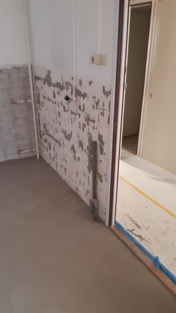 Een ruimte in renovatie met voorbereid vloer- en muurwerk door Elviservices.