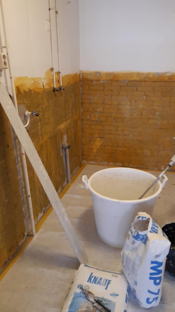 Voorbereiding van een keukenmuur met bakstenen muur en spuitgipsmaterialen door Elviservices.