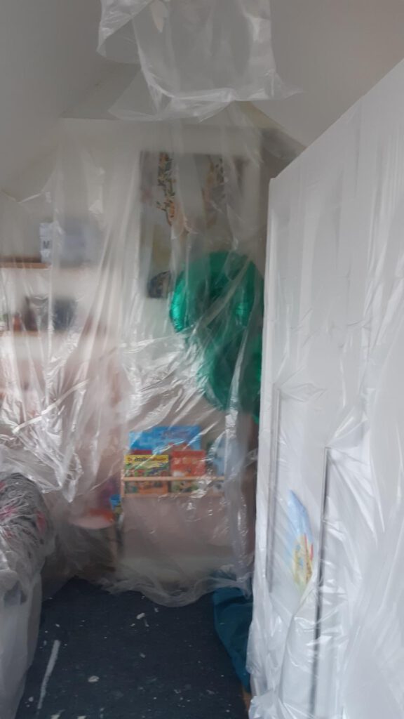 Afgedekte meubels in een ruimte beschermd tijdens renovatiewerkzaamheden door Elviservices.