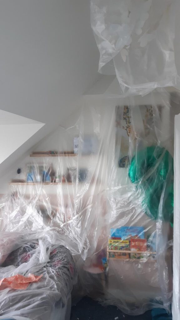 Renovatiewerkzaamheden in een beschermde ruimte met afgedekte meubels door Elviservices.