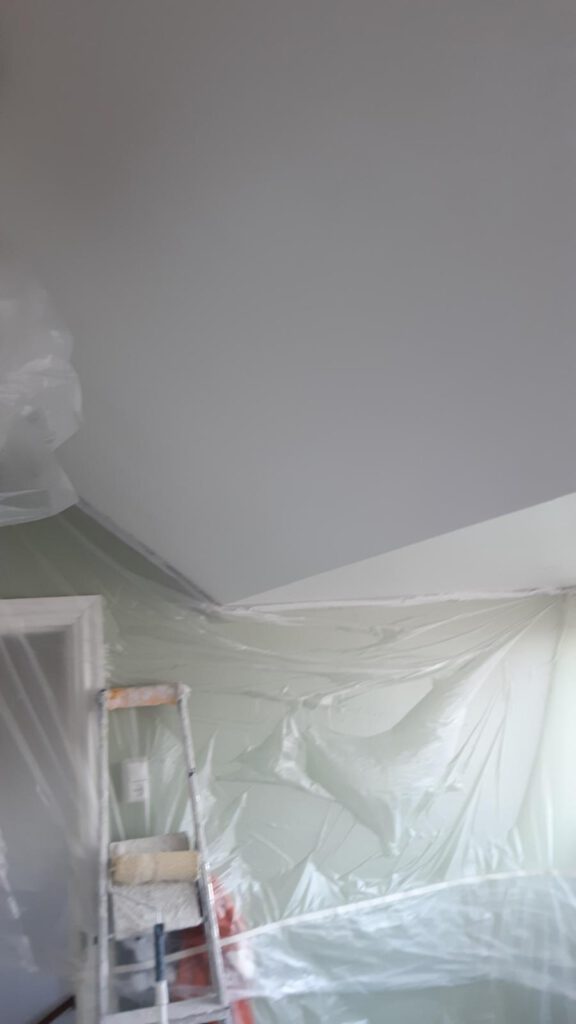 Strak afgewerkte slaapkamer met geschilderd plafond door klussenbedrijf Elviservices in Amsterdam.